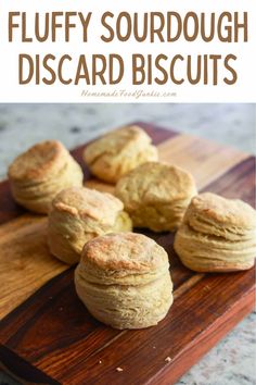 fluffy sourdough biscuits on a cutting board with text overlay that reads fluffy sourdough biscuits