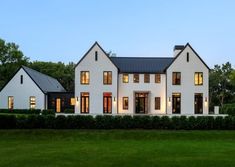 a large white house sitting on top of a lush green field