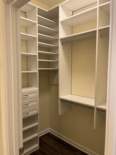 an empty walk in closet with white shelving