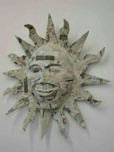 a sun made out of newspapers sitting on top of a wall