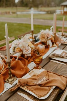 the table is set with candles, napkins and other items for an outdoor dinner