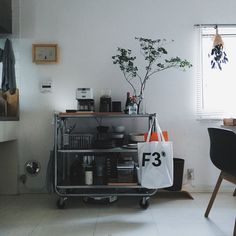 a kitchen with a table, chair and plant in it