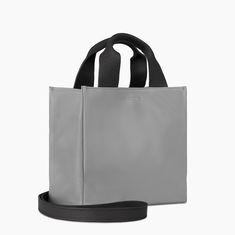 Introducing the Small Leather Tote Bag in Gray, a sleek and versatile accessory perfect for everyday use. This bag is expertly crafted from high-quality calf leather, offering a soft yet durable finish that ensures long-lasting wear. Its compact size makes it ideal for carrying your essentials while maintaining a minimalist and modern aesthetic. The bag features an inner phone sleeve with three card slots and an attached keyring, providing organized storage for your daily necessities. The outer Versatile Rectangular Leather Box Bag, Versatile Leather Box Bag With Adjustable Strap, Versatile Everyday Leather Box Bag, Soft Leather Box Bag For Everyday Use, Everyday Soft Leather Box Bag, Functional Textured Leather Bag For Everyday Use, Modern Coated Canvas Satchel Box Bag, Modern Faux Leather Shoulder Bag With Textured Detail, Everyday Use Box Bag In Soft Leather