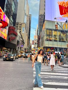 a woman is crossing the street in front of mcdonald's and other tall buildings