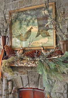 a mantel with pine cones, branches and birds on it in front of a painting