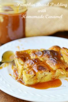 a white plate topped with french toast covered in caramel sauce and syrup next to a jar of honey