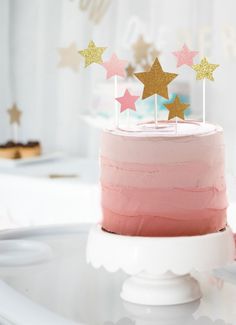 a pink cake with gold stars on top