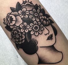 a woman's head with flowers in her hair is shown on the arm and leg