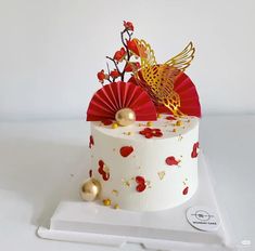 a white cake with red and gold decorations