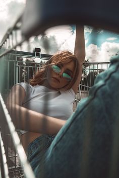 a woman sitting in a shopping cart wearing sunglasses