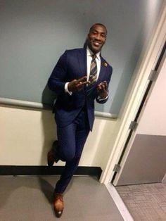 a man in a suit and tie is running through an office hallway with his cell phone