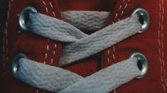 a close up view of a pair of red sneakers with white laces on them