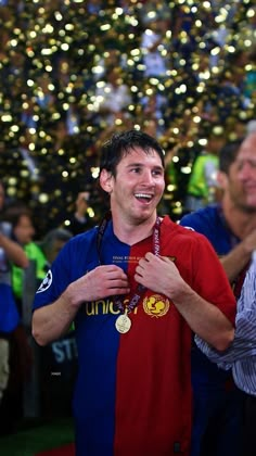 a man smiles as he stands in front of a christmas tree with his medal around his neck