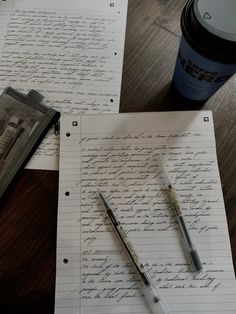 two papers with writing on them next to a cup of coffee and a pen sitting on top of it