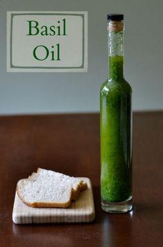 there is a bottle with basil oil next to a slice of bread