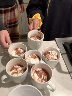 four cups of ice cream are on the counter