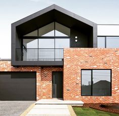 a brick house with two garages on the front and second story is shown in this image