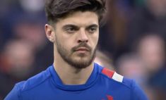 a close up of a soccer player wearing a blue shirt and looking at the camera