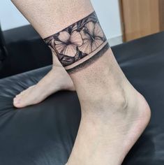 a woman's leg with a flower tattoo on her left side and the bottom part of her foot