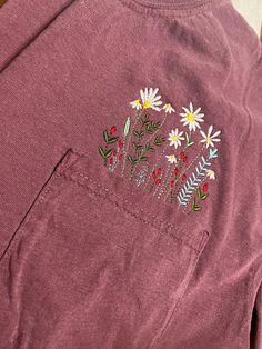 "Wildflowers can't be controlled, and neither can the girl with a soul boundless as the sky, and a spirit as free and wild as the ocean." These are the perfect spring and summer shirt that can easily be dressed up or down! Embroidered and shipped from Alabama  Embroidered on Comfort Colors 6.1 oz 100% ring spun cotton. *PROCESSING TIME* We need 3-5 business days for production once an order is placed. We ship USPS First Class which takes 3-5 days. *Return and Exchange Policy* All sales are final. Due to these being custom made to order we do not allow returns, or exchanges. If you have any questions please do not hesitate to send us a message. Pink Summer Tops With Embroidered Graphics, Cute Summer Tops With Embroidered Graphics, Cute Embroidered Graphic Tops For Spring, Pink Embroidered Tops For Summer, Spring Cotton Tops With Embroidered Graphics, Red Summer Style T-shirt For Spring, Cute Red Tops With Floral Embroidery, Hippie Style Pink Cotton Tops, Spring Floral Embroidered Short Sleeve Camp Shirt