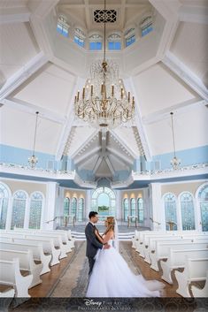 a bride and groom standing in front of the alter at their wedding ceremony with chandeliers hanging from the ceiling