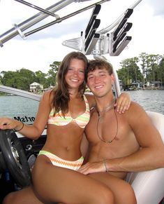 a man and woman sitting on the back of a boat