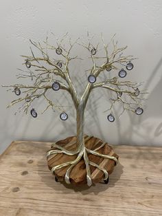 a tree with many ornaments on it sitting on top of a wooden table