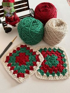 two crocheted coasters with balls of yarn next to them