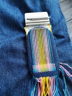 a close up of a colorful comb on blue jeans