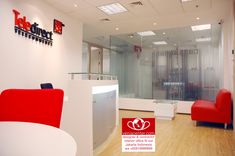 the interior of a modern office with red and white furniture