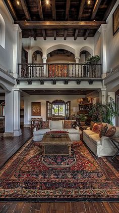 a large living room with high ceilings and wooden floors