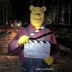 a man in a bear costume holding a clap board