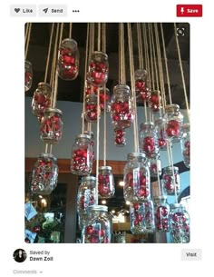 a chandelier filled with lots of red balls and hanging from it's ceiling