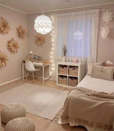 a bedroom decorated in neutrals and whites with flowers on the wall, lights hanging from the ceiling