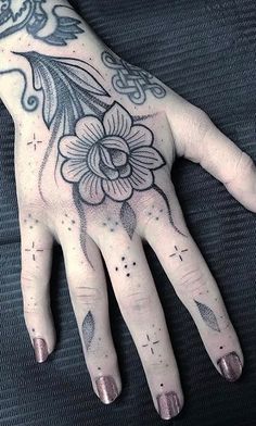 a person's hand with tattoos on it and a flower tattooed on the palm