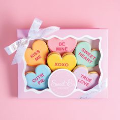 heart shaped cookies in a box on a pink background