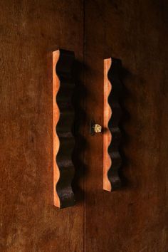 the door is made of wood and has two handles on each side, one with a brass knob