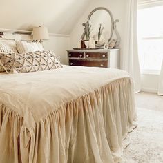 a bed sitting under a window in a bedroom next to a dresser and lamp on top of a rug