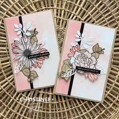 two cards with flowers on them sitting on a wicker basket