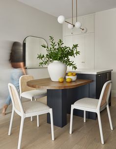 a dining room table with chairs and a potted plant in the center surrounded by yellow lemons