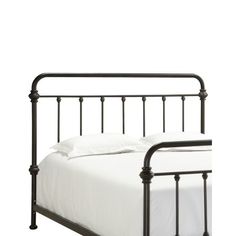 an iron bed frame with white sheets and pillows on the headboard, against a white background