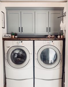 a washer and dryer in a laundry room with cabinets above them, next to each other