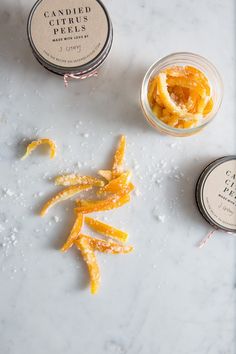 candied citrus peels on a table next to two small jars filled with them