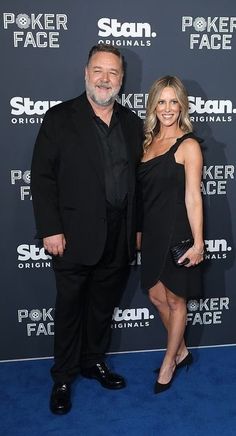 a man and woman are standing together on the blue carpet in front of a black backdrop