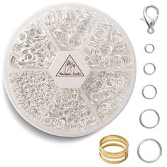 an assortment of rings and ring sets on top of a white plate with two gold rings in the middle