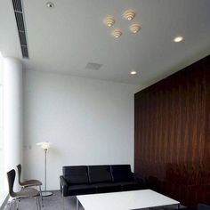 a living room filled with black furniture and white walls