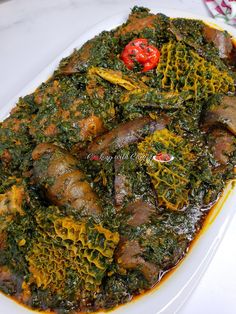 a white plate topped with meat covered in greens