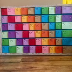 a multicolored board with numbers on it sitting on top of a wooden floor