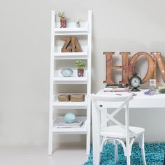 a white desk and chair in front of a shelf with letters that spell out the word home