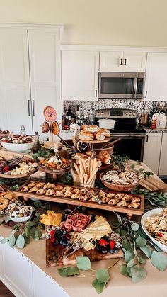 a table filled with lots of food on top of a kitchen counter